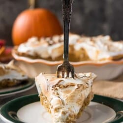 A slice of pumpkin pie with meringue on a plate.
