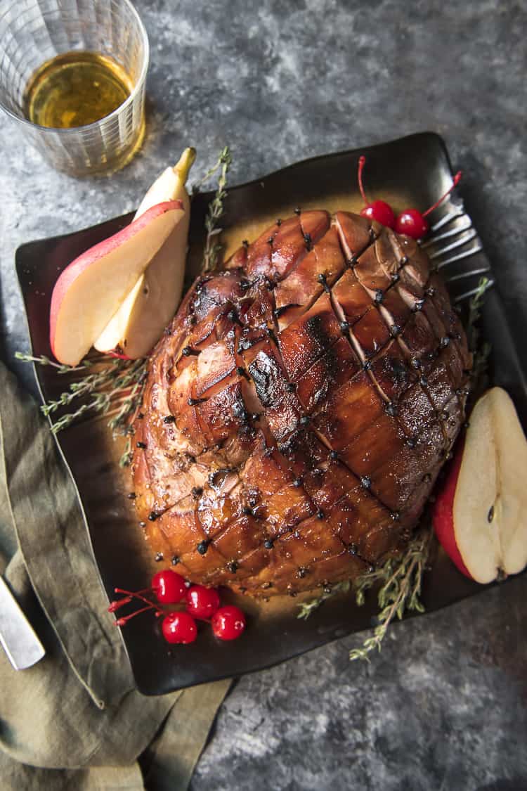 Top shot of Bourbon Honey Baked Ham with pears, thyme, and cherry garnish