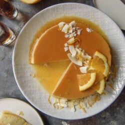 Flan de coco on a plate with a slice removed.