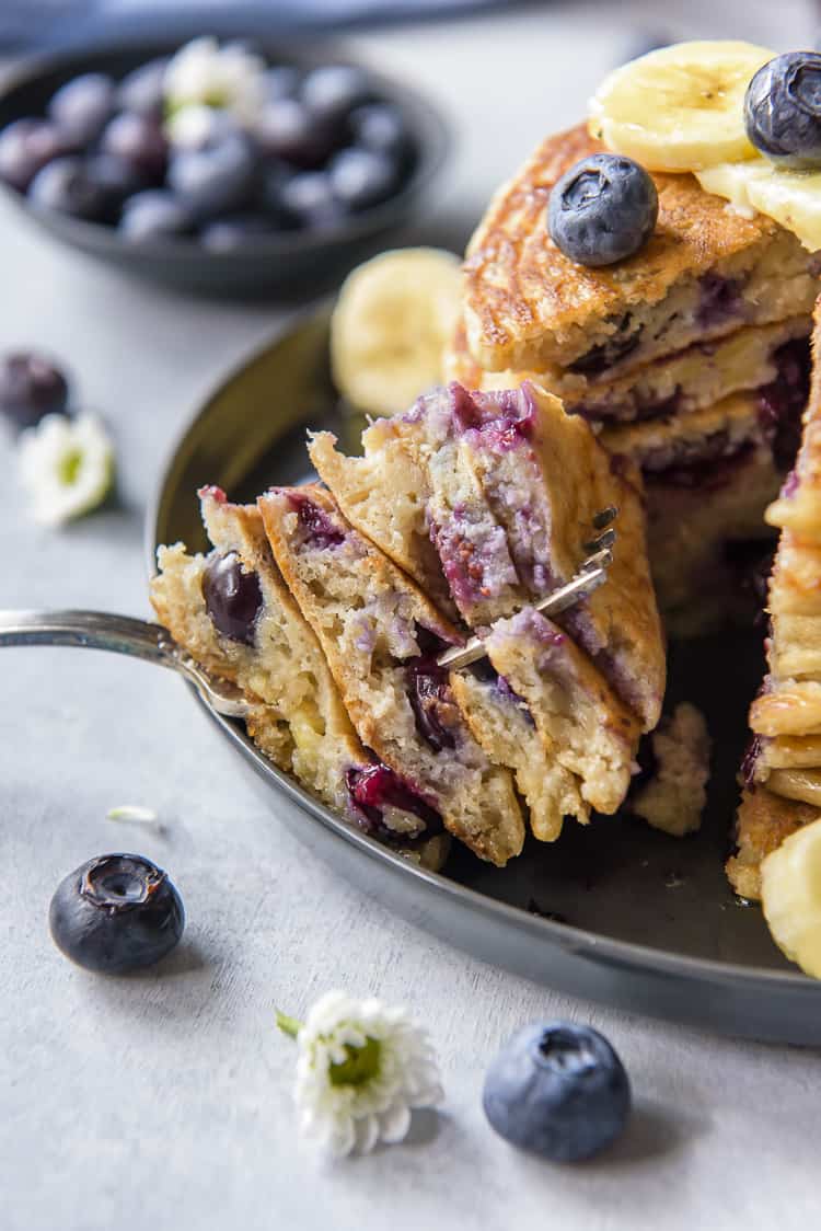 A forkful of fluffy Banana Pancakes with blueberries