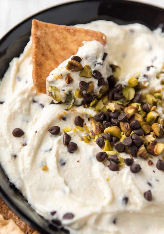 A chip in a bowl of Cannoli Dip