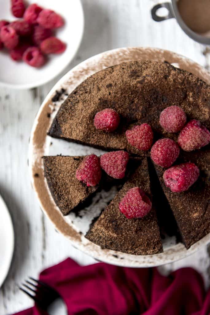 Top shot of a Flourless Chocolate Espresso Cake garnished with fresh raspberries
