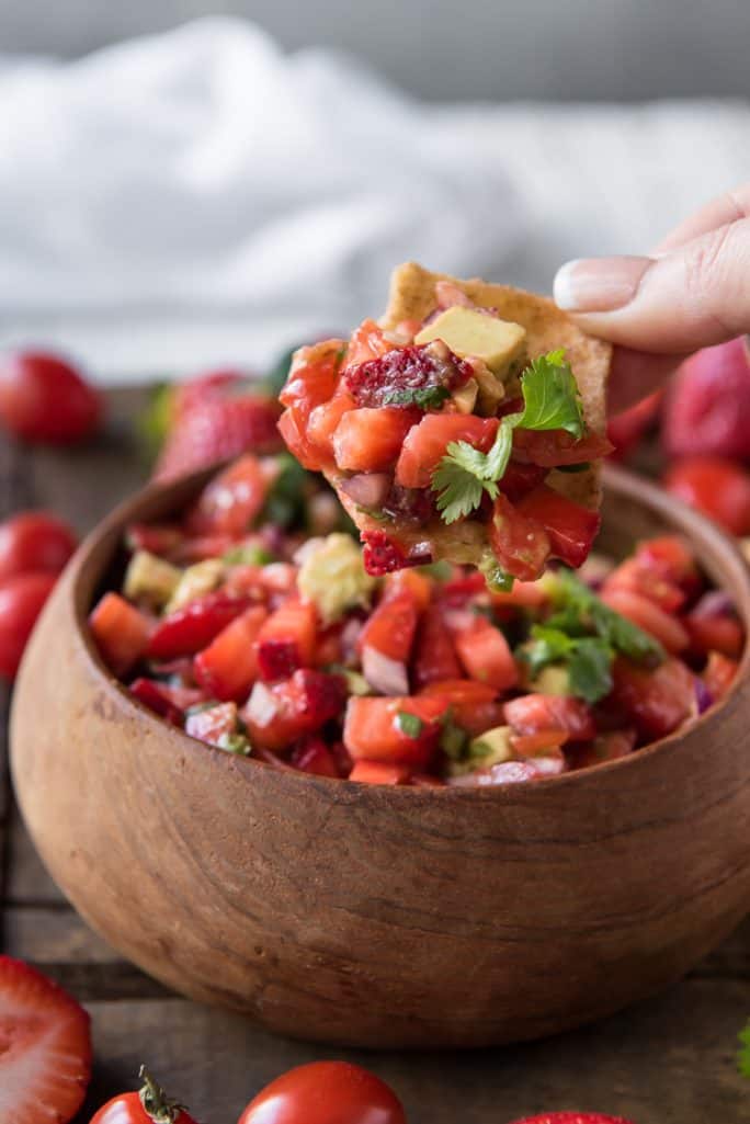 A scoop of Fresh Strawberry Tomato Salsa on a chip
