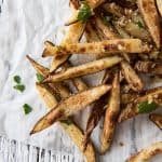 Baked garlic and Parmesan truffle fries on parchment paper