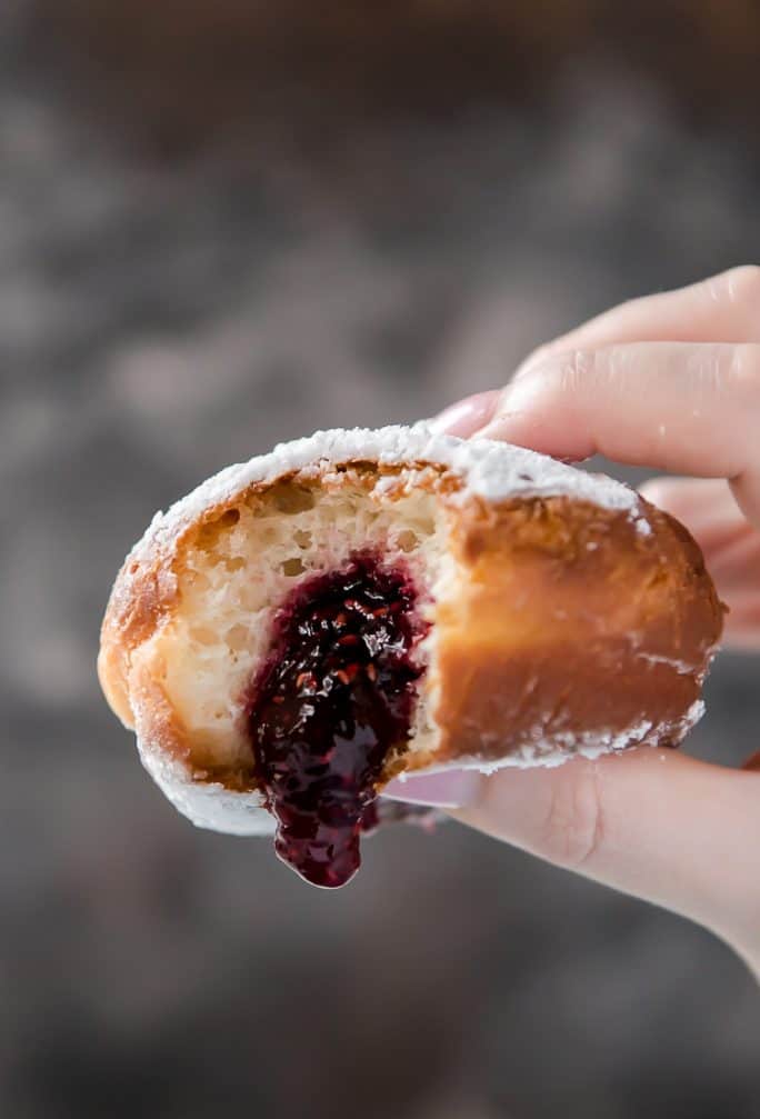 Squeezing a paczek (Polish donut) with jam oozing out