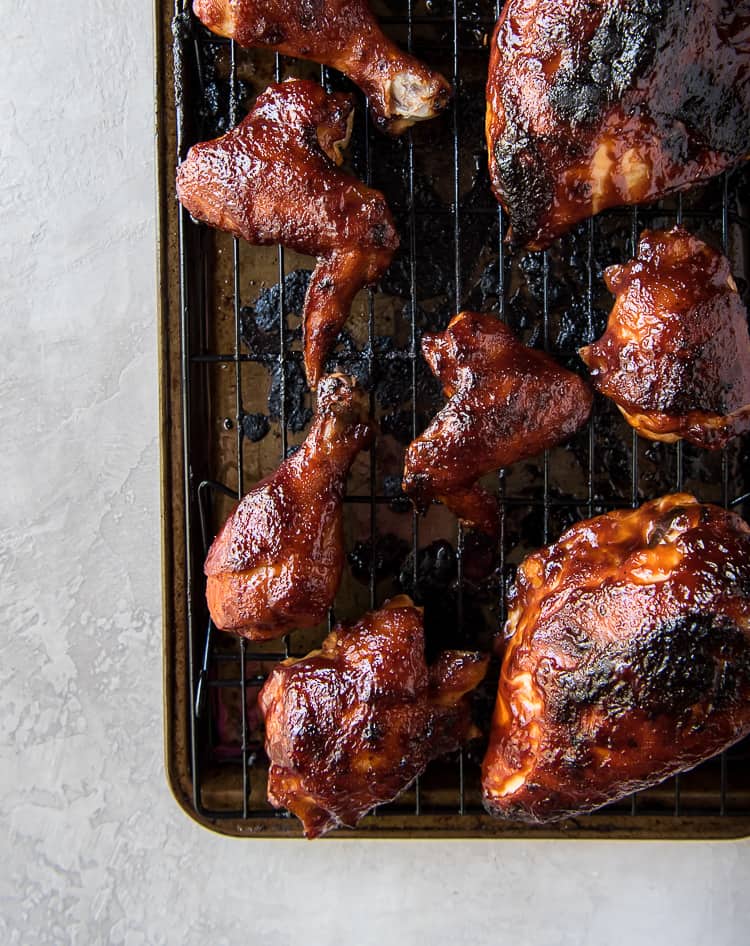 Baked BBQ chicken pieces on a baking sheet.
