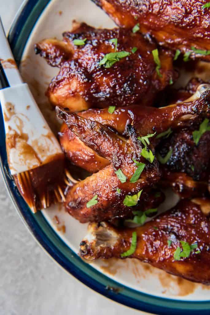 Barbecue Chicken recipe baked in oven, set on a plate with a basting brush