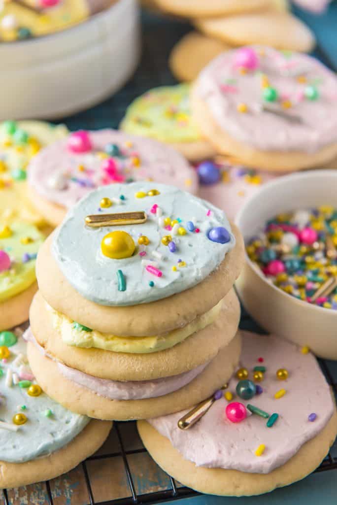 A stack of soft frosted sugar cookies with sprinkles
