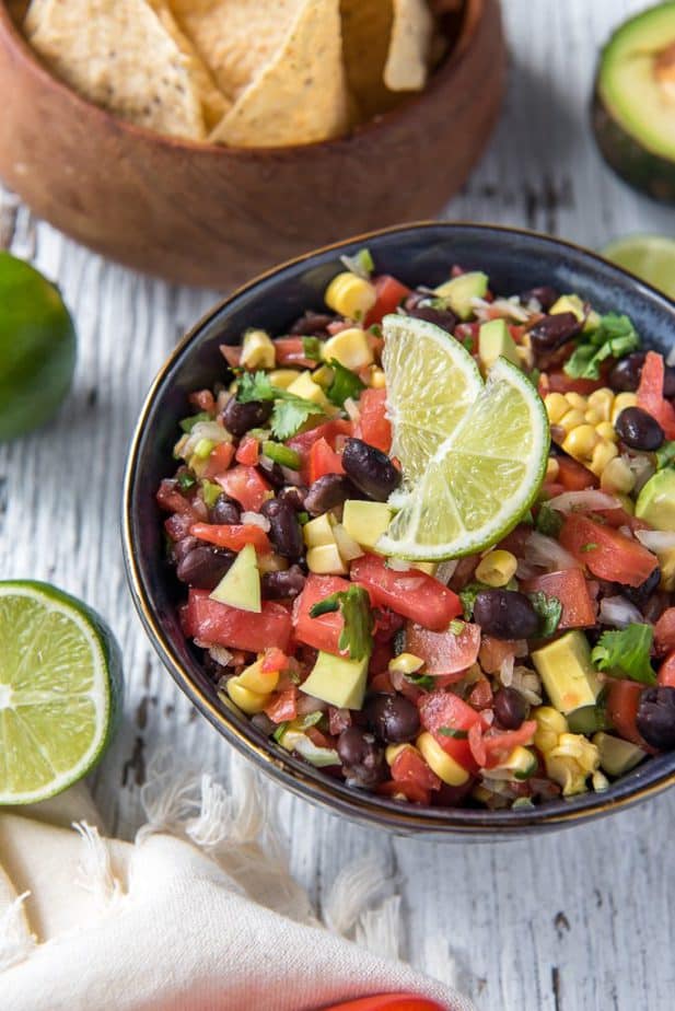 Mexican Avocado Black Bean and Corn Salsa in a bowl with lime slices