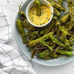 Instant Pot Blistered Shishito Peppers on a plate with a dipping sauce