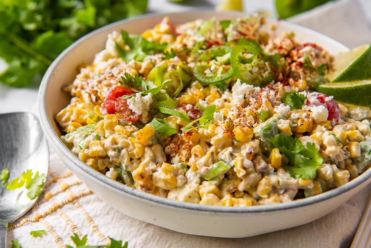 Mexican Street Corn Salad topped with jalapeno and lime in a bowl