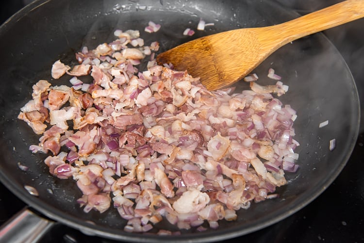 Chopped bacon frying in a skillet
