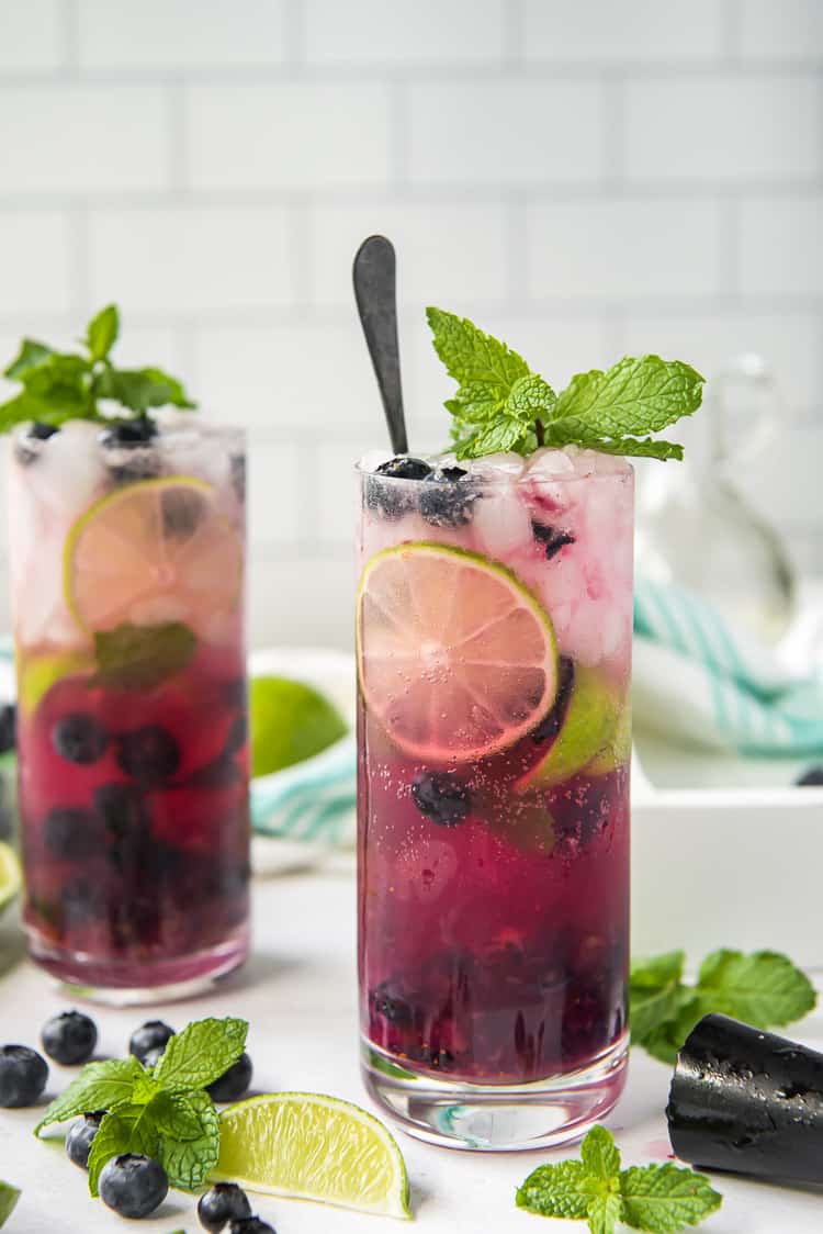 a blueberry mojito drink with a spoon inside