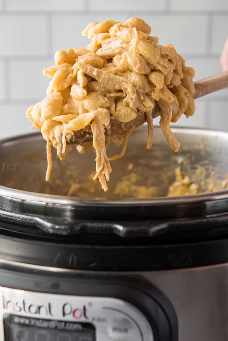 BBQ chicken mac and cheese being lifted from an instant pot