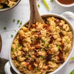 BBQ chicken macaroni and cheese in a white serving dish with a spoon