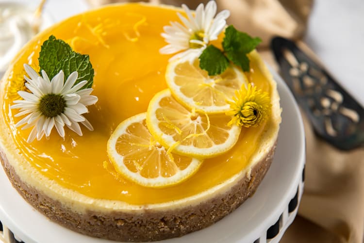 an Instant Pot Lemon Ricotta Cheesecake decorated with lemon slices and flowers
