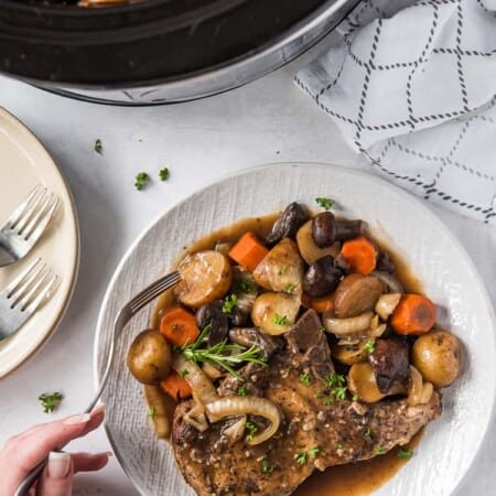 crock pot pork chop on a plate with vegetables