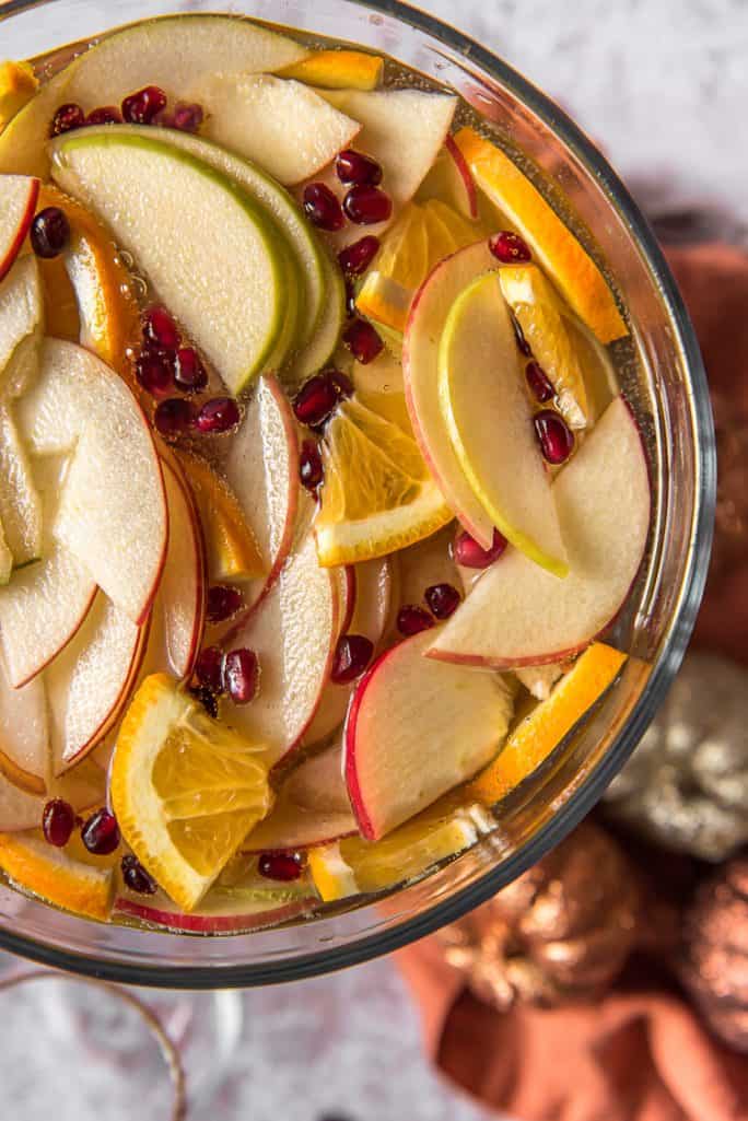 top shot of a punch bowl filled with pumpkin sangria and apples