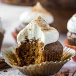 a chai pumpkin cupcake with a bite taken out of it