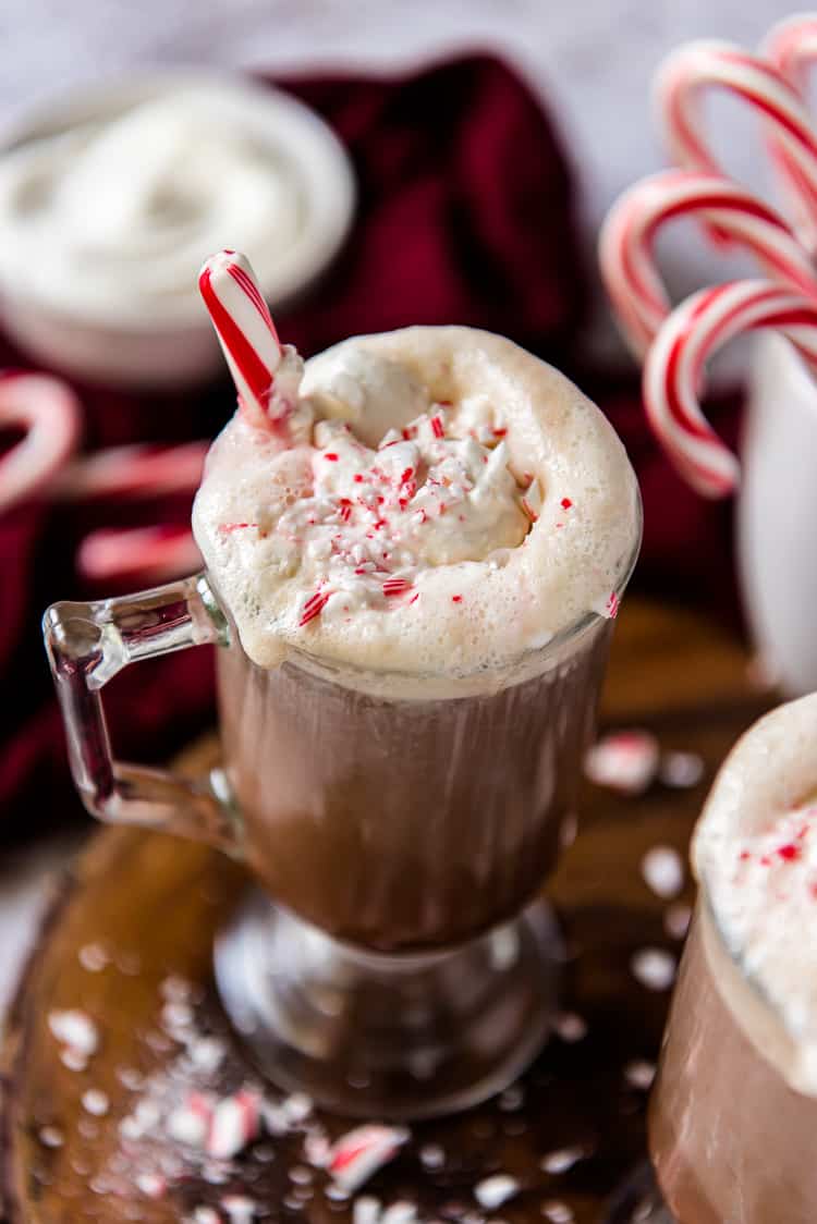 a mug of boozy hot cocoa with a peppermint stick in it