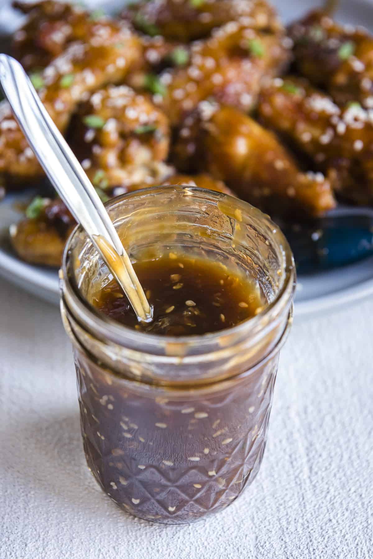 homemade teriyaki sauce in a mason jar with a spoon inside
