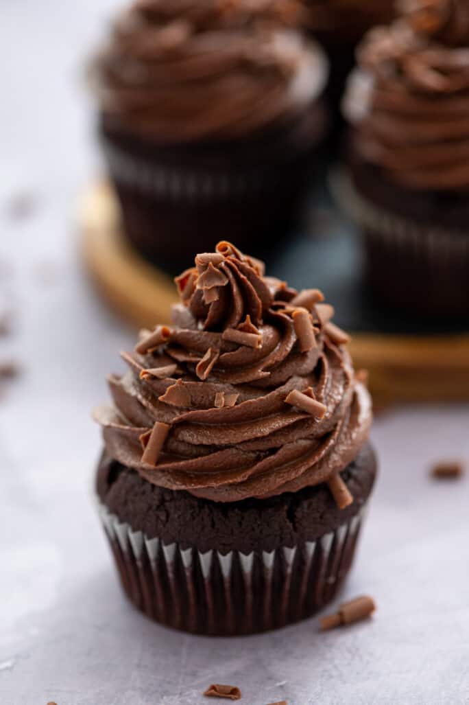 chocolate buttercream on a chocolate cupcakes with chocolate curls on top