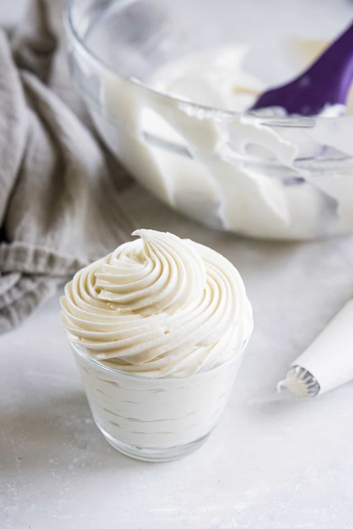 whipped cream cheese frosting piped into a small glass container