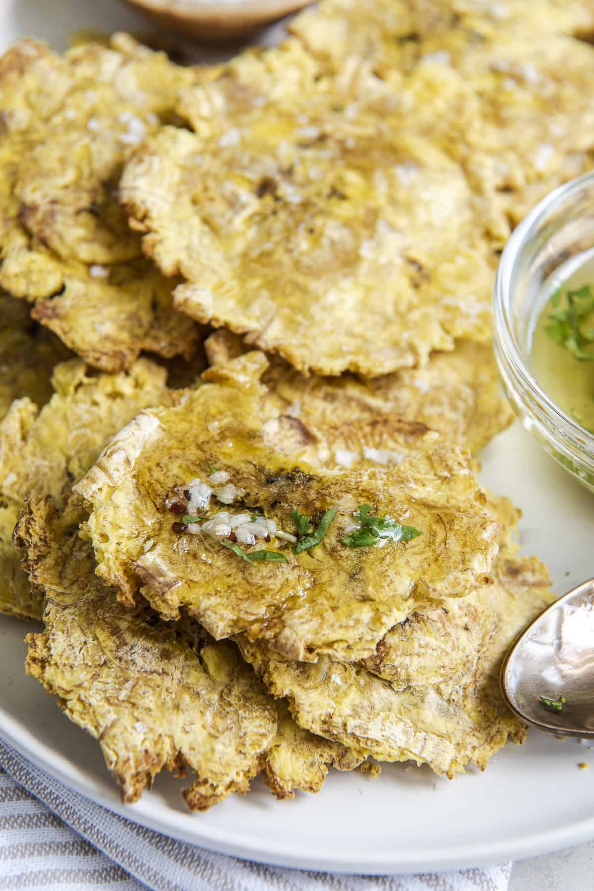 air fried tostones with garlic oil on a white plate