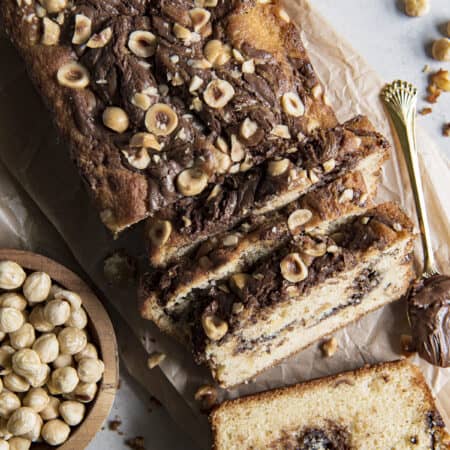 a cut loaf of nutella bread with hazelnuts on top