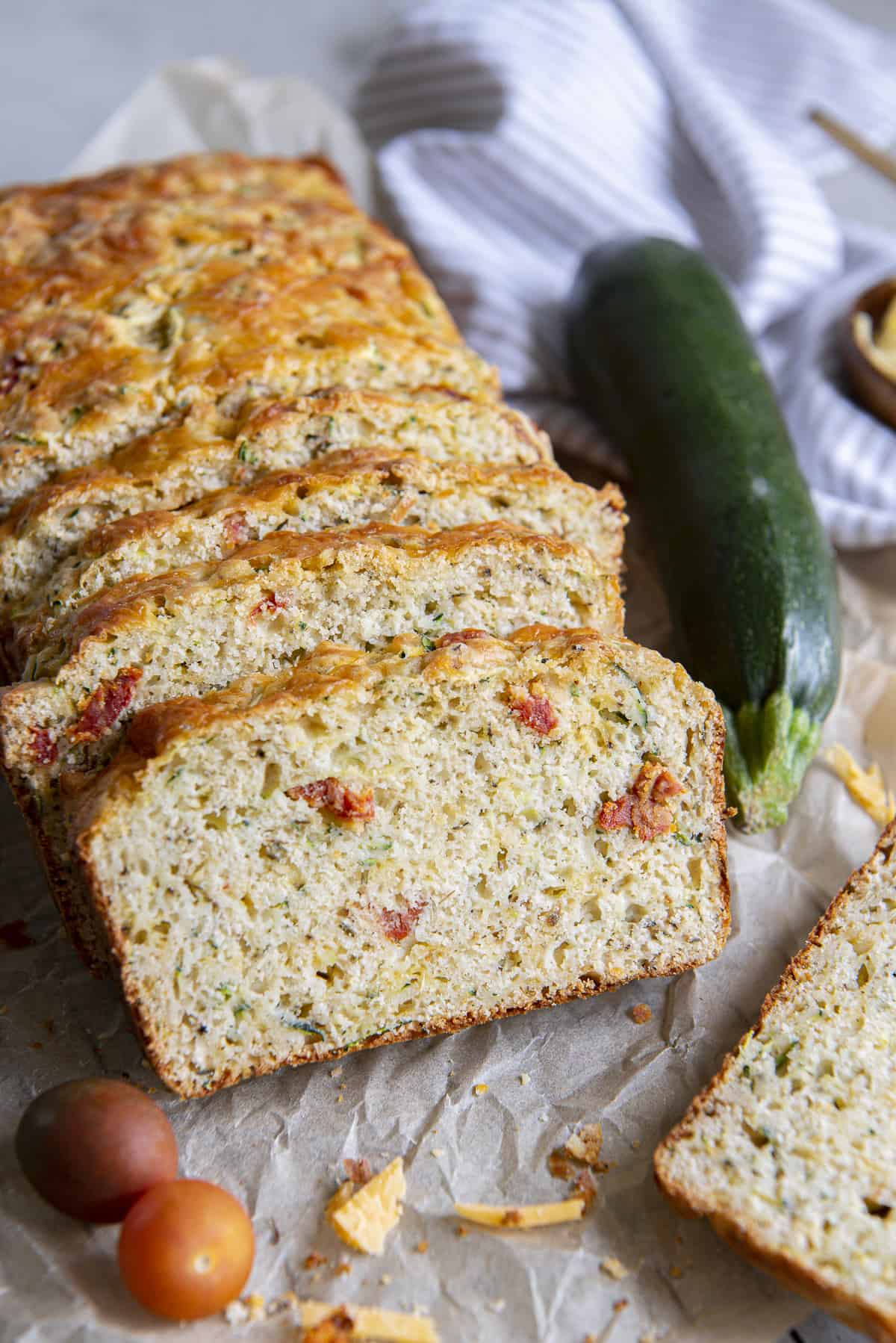 several slices of savory zucchini bread shingled together with veggies surrounding them