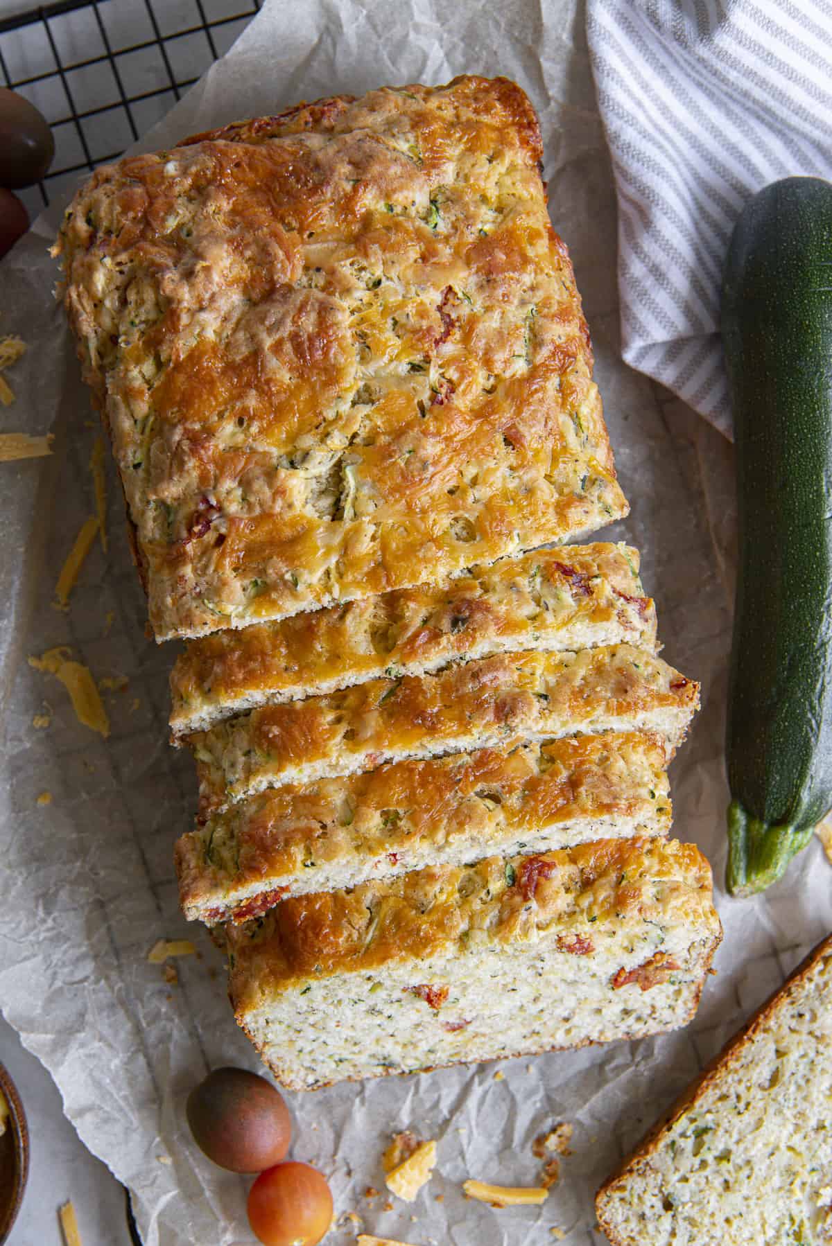 a loaf of savory zucchini bread with several slices cut into it, shingled together