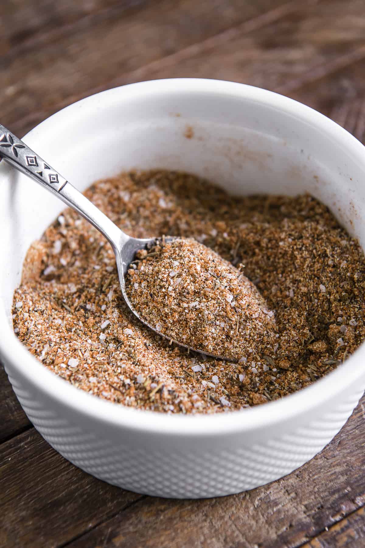 a spoonful of blended chicken seasoning in a white bowl