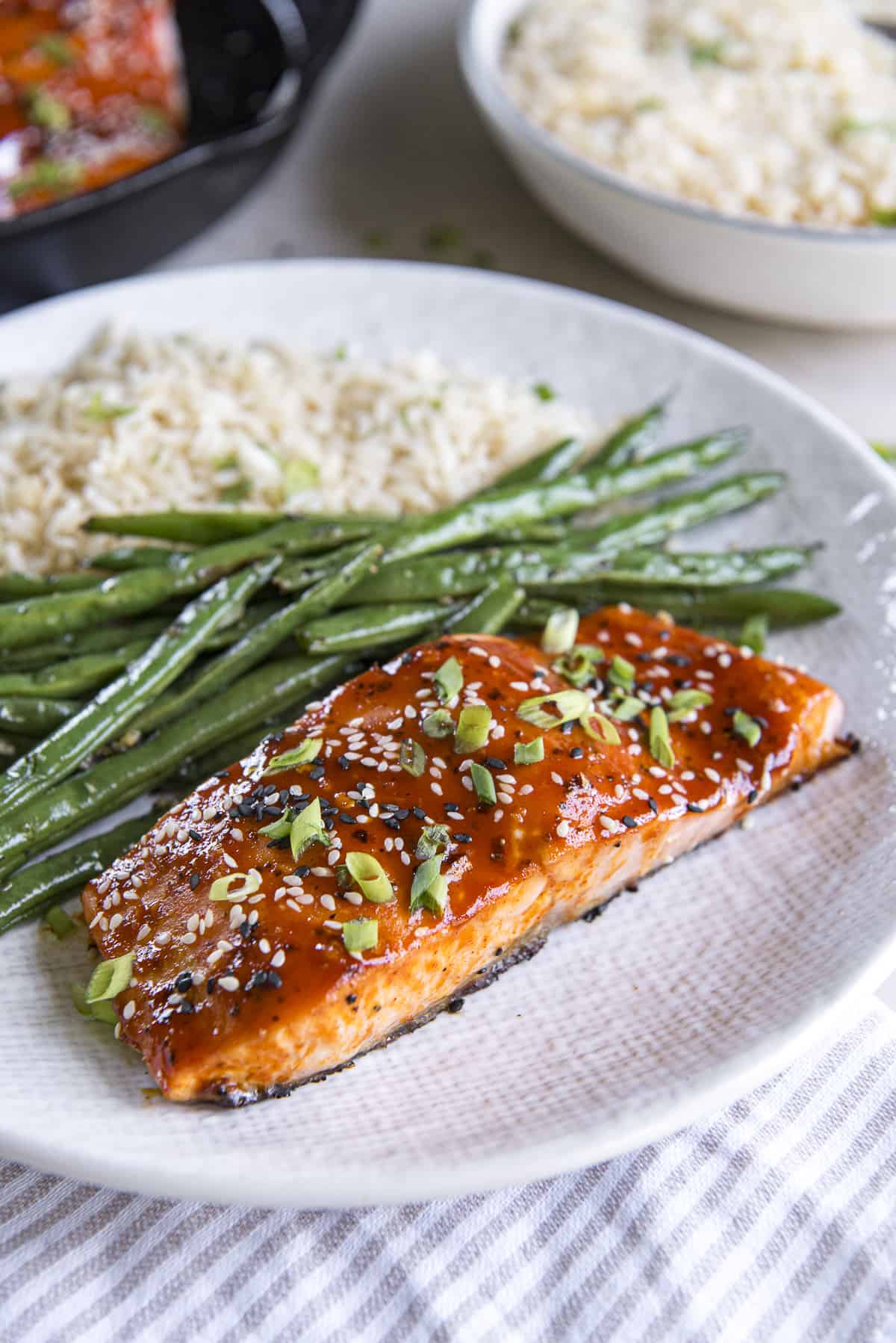 A plate with salmon, green beans and rice.
